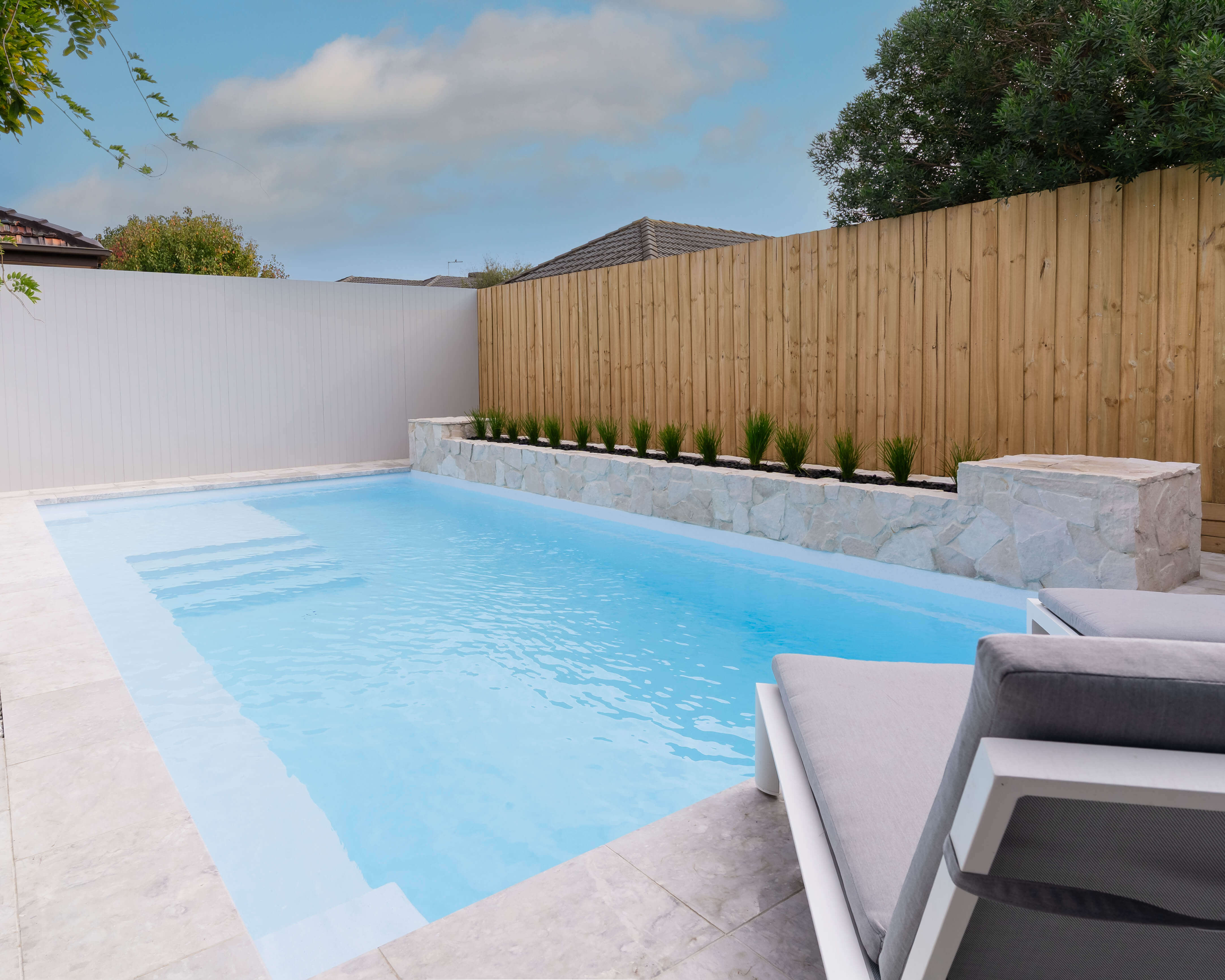 Close-up of textured pool tiles and running water feature in a modern Melbourne backyard pool.